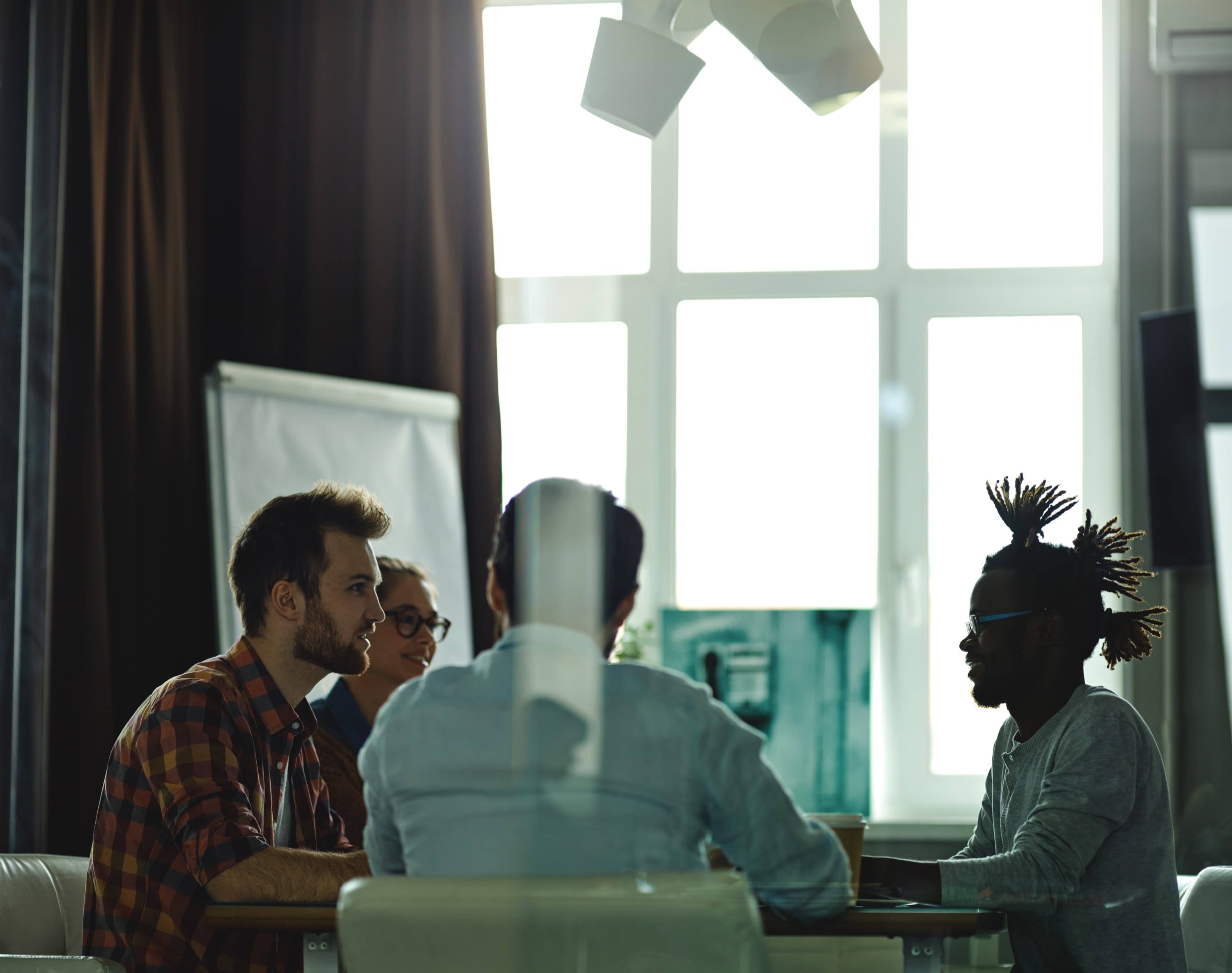 A team talking around a table in a bright meeting room